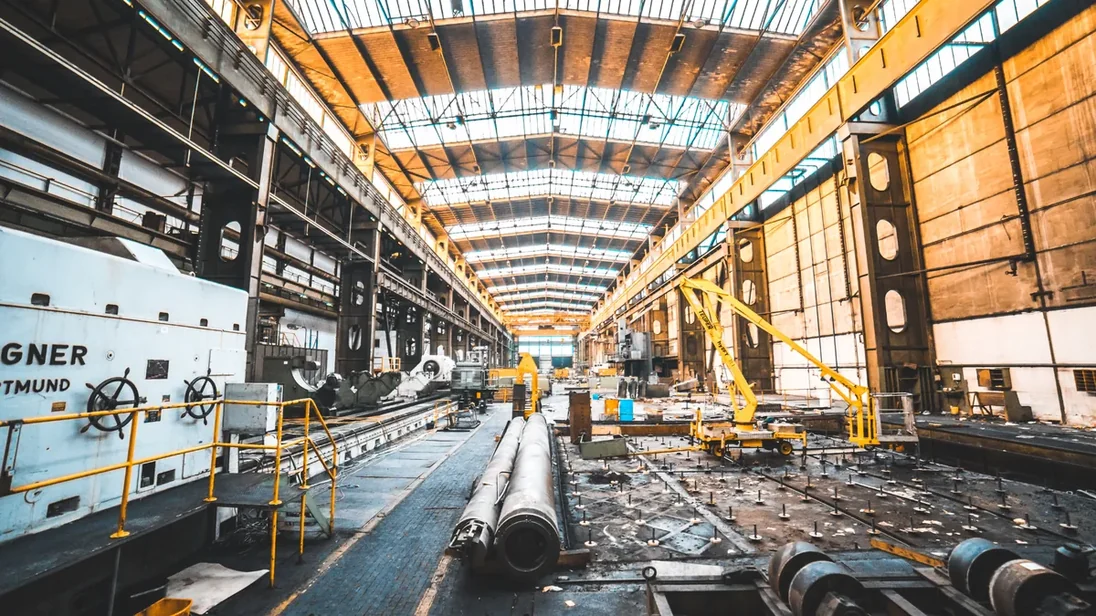 Interior de fábrica com estrutura metálica e linha de montagem